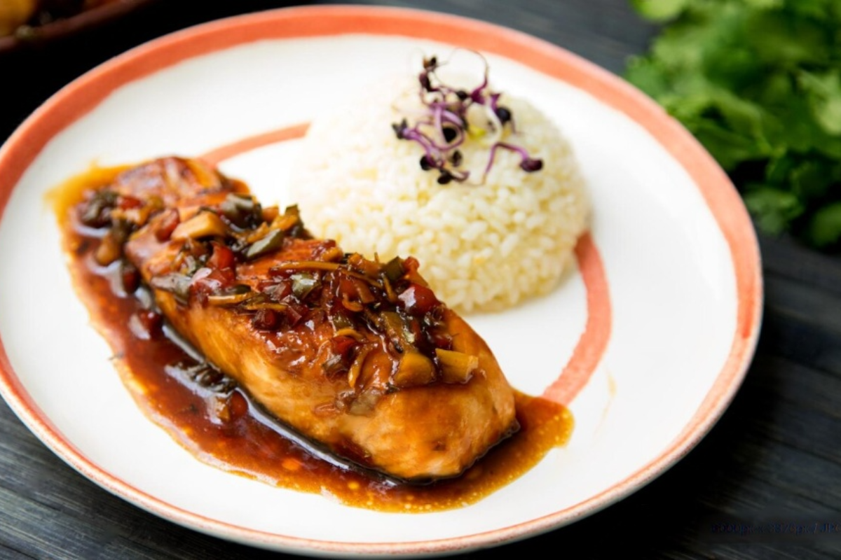 A beautifully plated Bangus Ala Pobre, featuring golden-brown fried marinated bangus topped with crispy garlic bits and caramelized onions. 