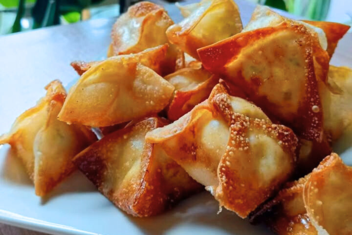 A plate of crispy Crab Rangoon Lumpia, golden brown.