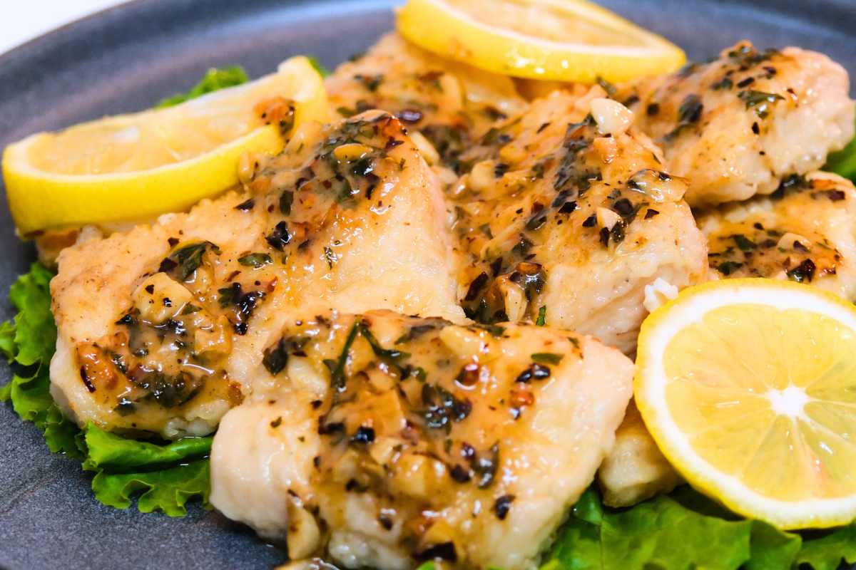 A plate of Lemon Butter Garlic Cobbler, featuring crispy Fishta Cobbler Fillet coated in a golden, zesty butter garlic sauce with chili flakes and parsley.