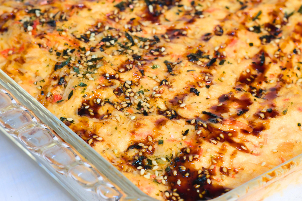 A delicious Salmon Sushi Bake in a baking dish, layered with seasoned rice, creamy salmon mixture, and furikake, baked to golden perfection.